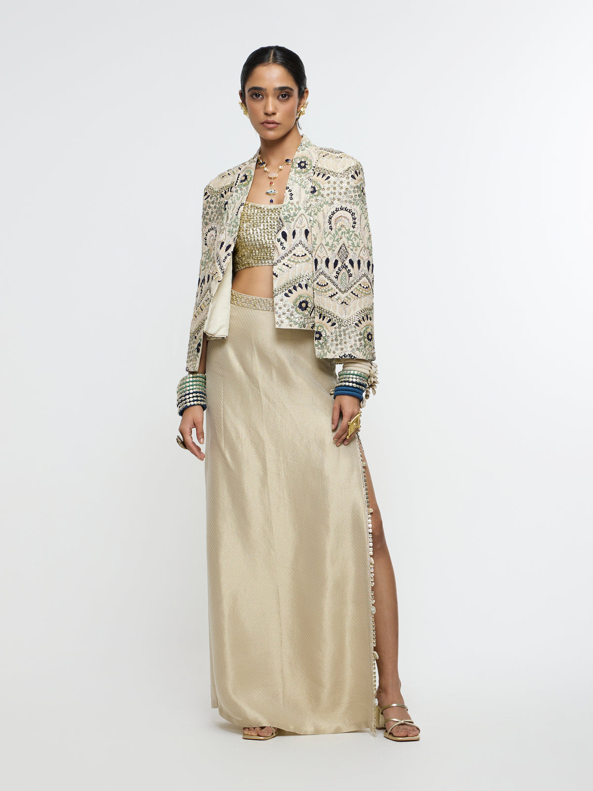 INAYAT EMBELLISHED CAPE JACKET PAIRED WITH METALLIC SCALLOP BUSTIER AND IVORY SLIT SKIRT