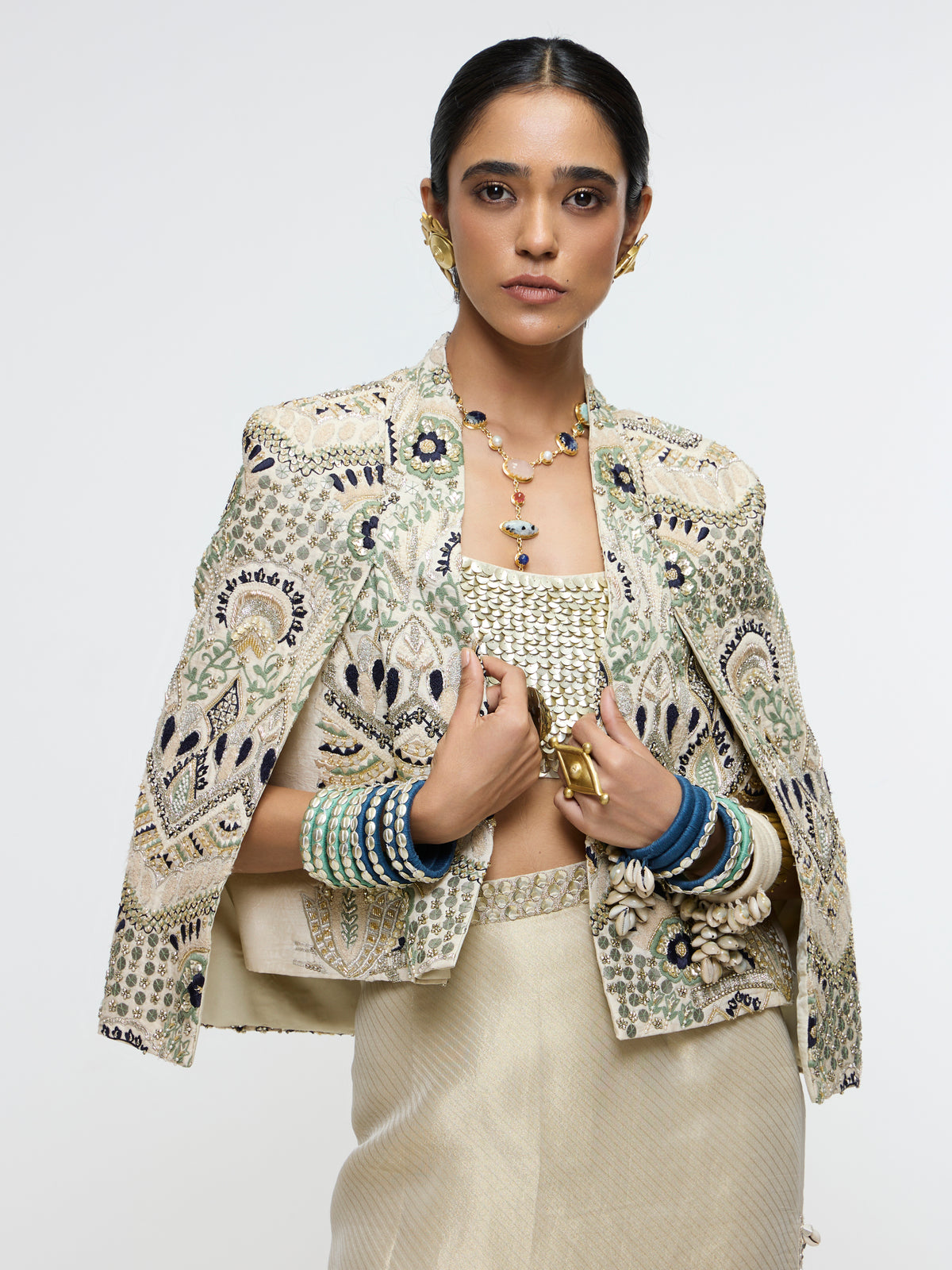 INAYAT EMBELLISHED CAPE JACKET PAIRED WITH METALLIC SCALLOP BUSTIER AND IVORY SLIT SKIRT