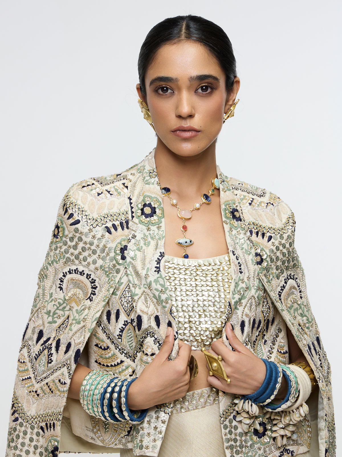 INAYAT EMBELLISHED CAPE JACKET PAIRED WITH METALLIC SCALLOP BUSTIER AND IVORY SLIT SKIRT