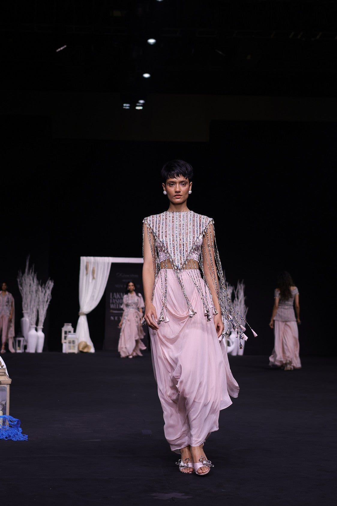 Peachy Pink ajrakh stripwork jacket paired up with Peachy pink bralette and drape dhoti skirt