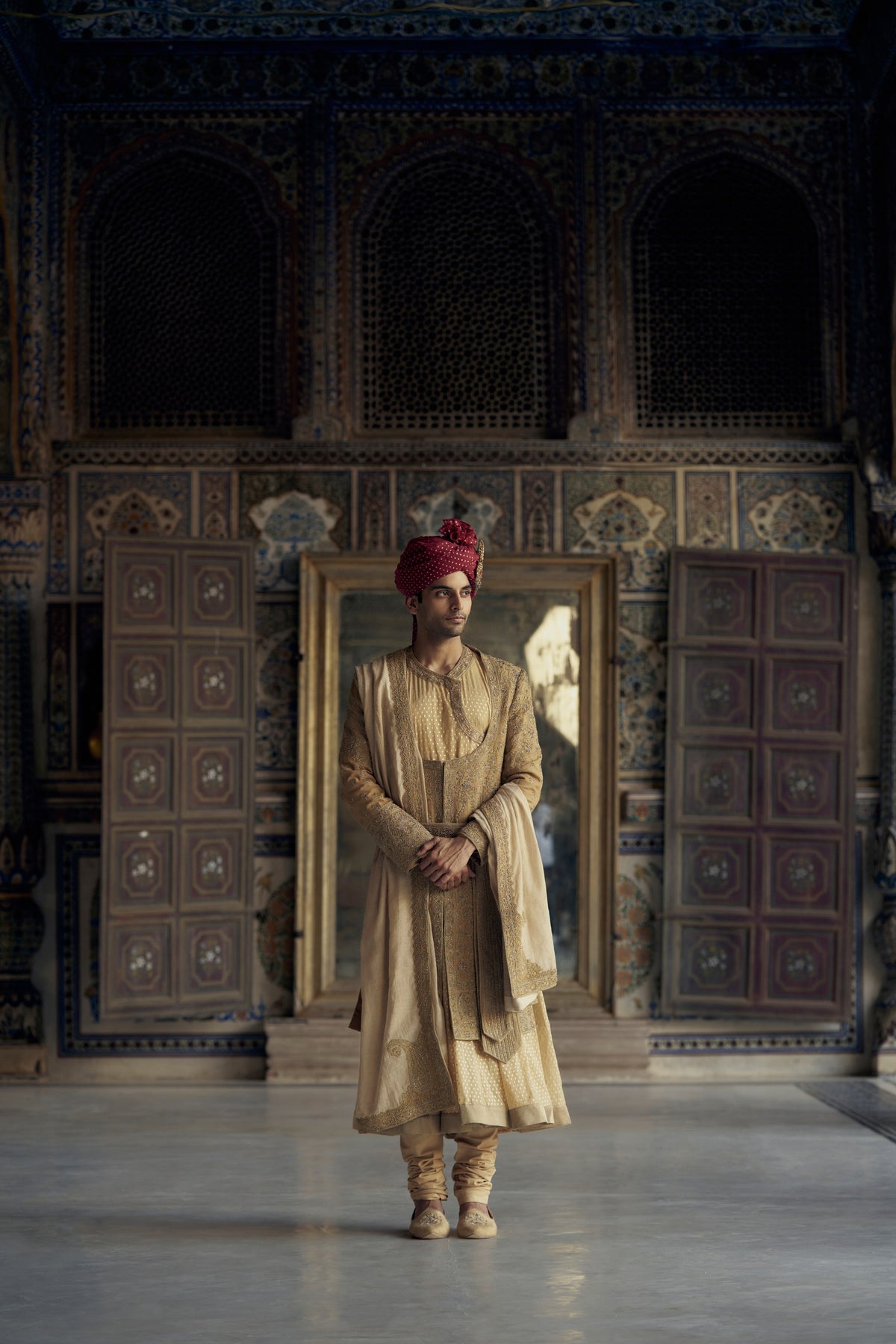 GOLD MATKA SILK ANGRAKHA STYLE SHERWANI WITH CHANDERI BOOTI CHOGA AND CHURIDAR WITH OPTIONAL BELT, STOLE AND WORKED JUTIS
