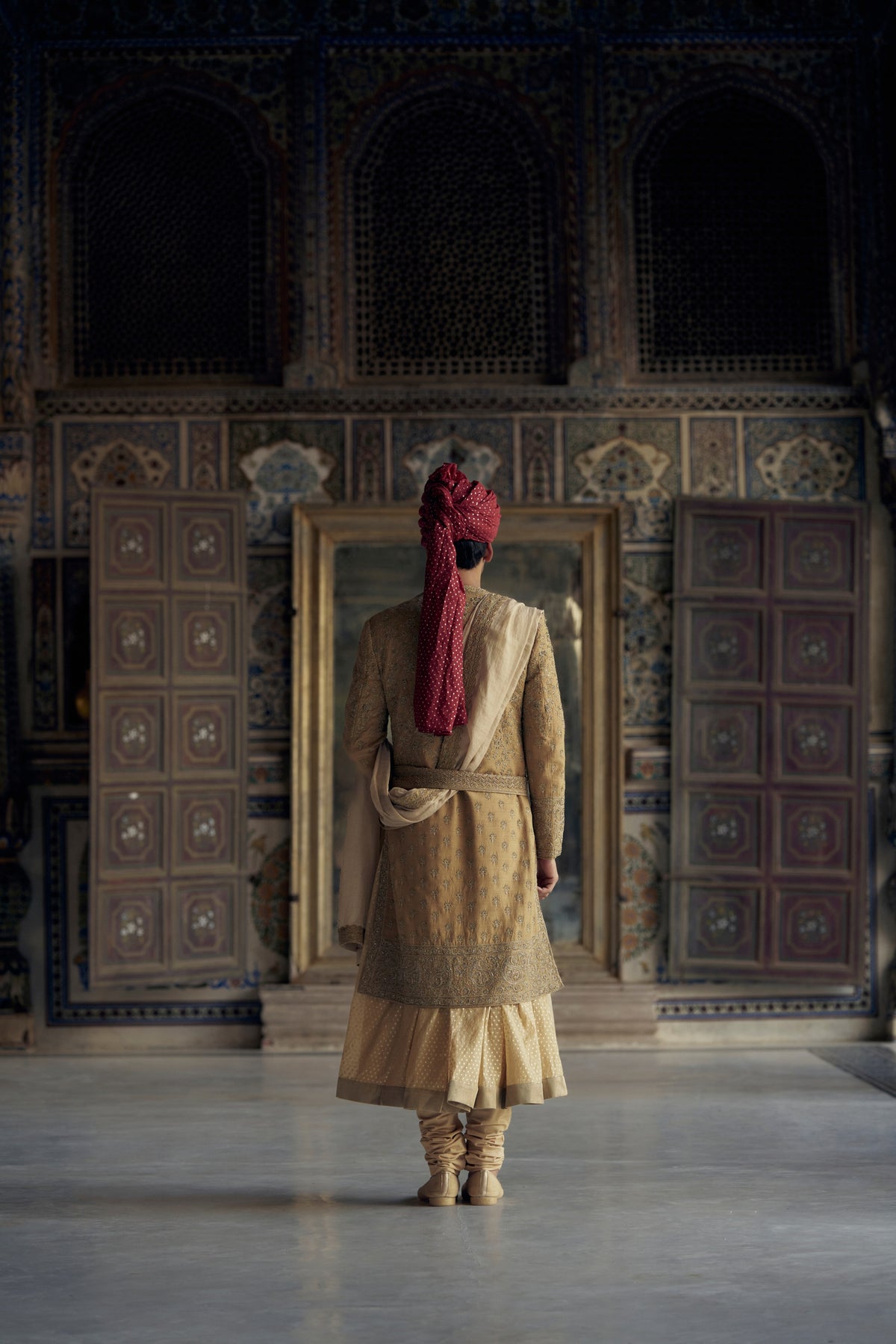 GOLD MATKA SILK ANGRAKHA STYLE SHERWANI WITH CHANDERI BOOTI CHOGA AND CHURIDAR WITH OPTIONAL BELT, STOLE AND WORKED JUTIS