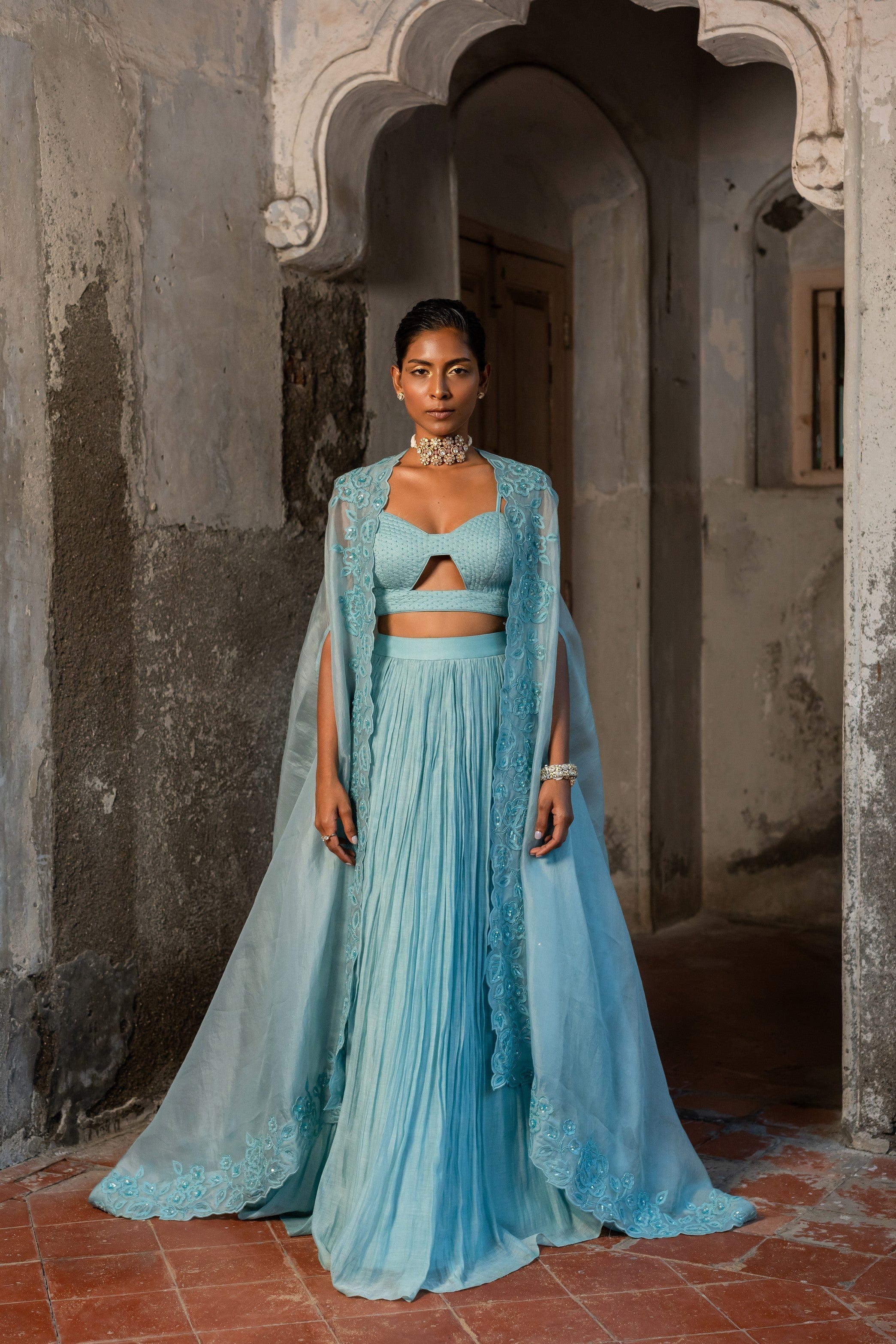 A pwder blue lehenga with maching blouse and cape