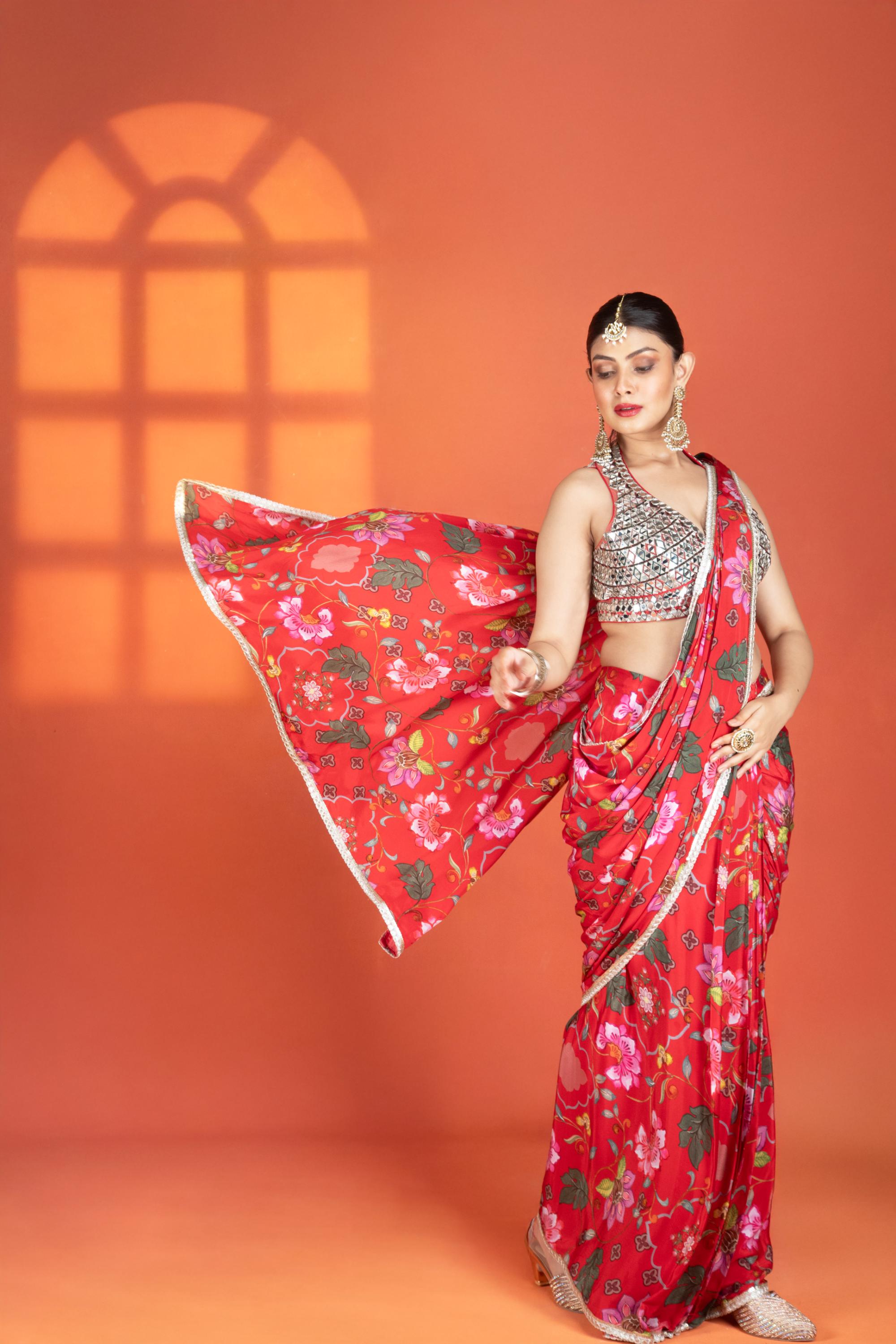 Red floral printed drape saree paired with a heavy mirror-work blouse.