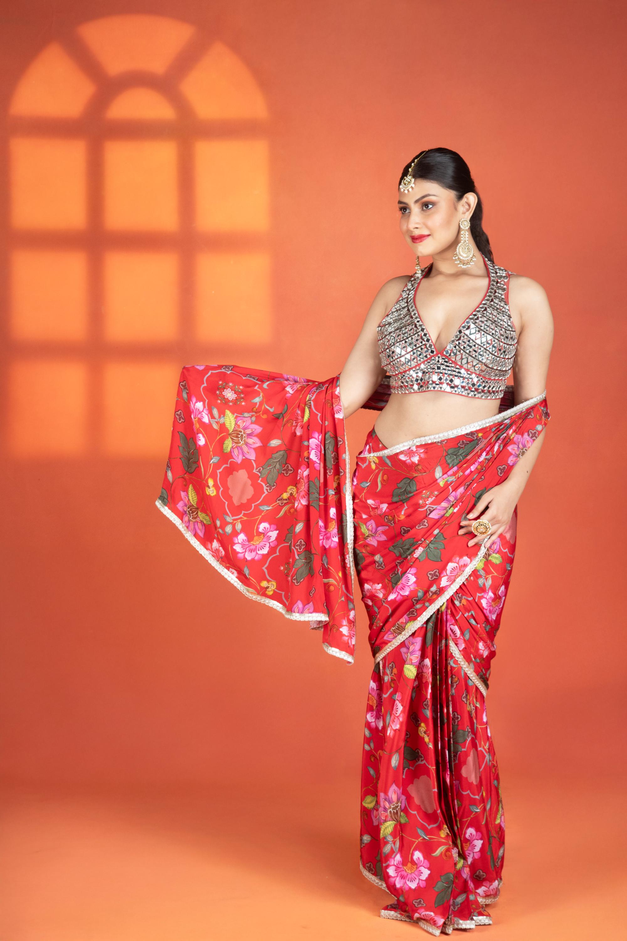 Red floral printed drape saree paired with a heavy mirror-work blouse.