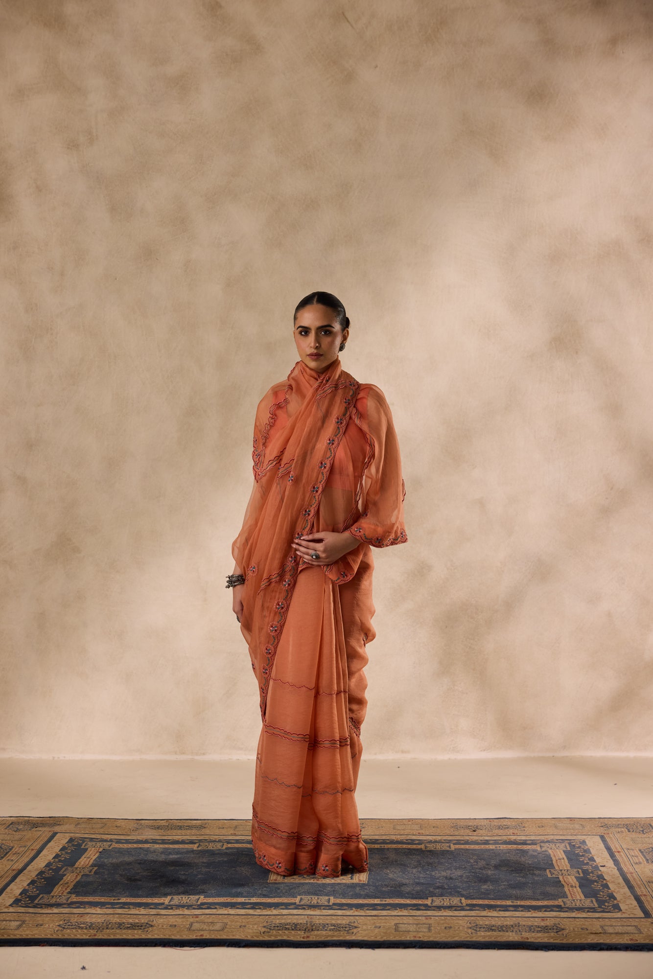 Peach organza scalloped embroidered saree comes with unstitched & unembroidered blouse fabric in chanderi