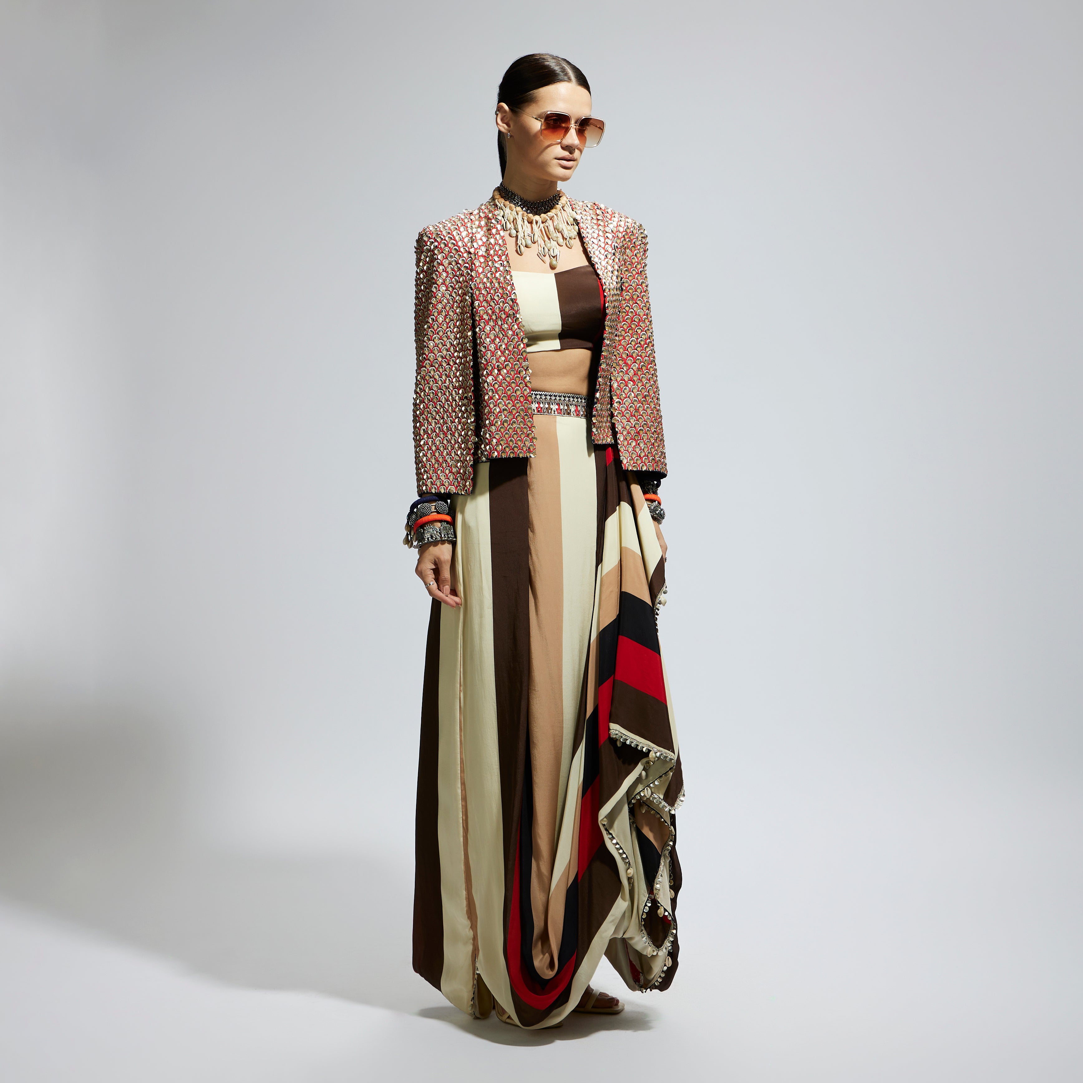 METALLIC EMBELLISHED CAPE JACKET PAIRED WITH STRIPE BUSTIER AND STRIPE DRAPE SKIRT
