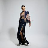 BLUE ASYMETRIC THREADWORK CAPE JACKET PAIRED WITH AN EMBELLISHED BUSTIER AND HIGH SLIT SKIRT