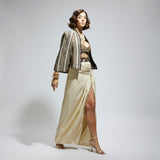 EMBELLISHED & TEXTURED CAPE JACKET PAIRED WITH METALLIC SCALLOP BUSTIER AND IVORY HIGH SLIT SKIRT