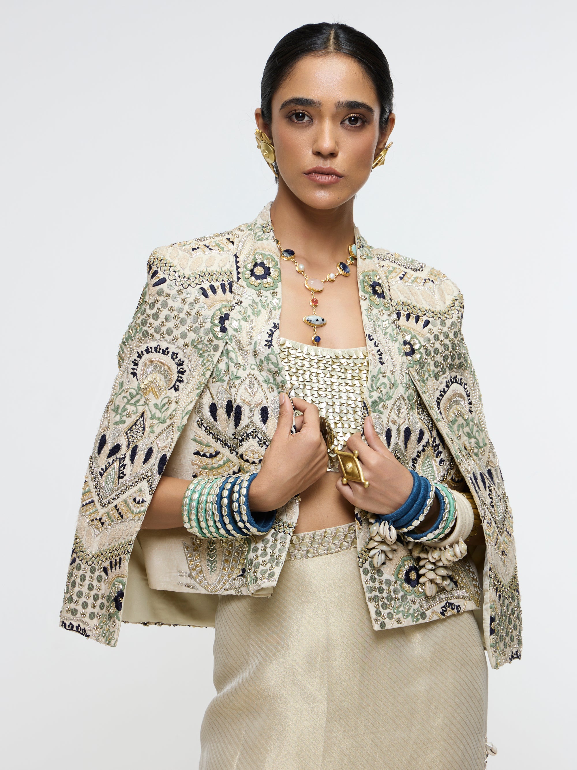 INAYAT EMBELLISHED CAPE JACKET PAIRED WITH METALLIC SCALLOP BUSTIER AND IVORY SLIT SKIRT