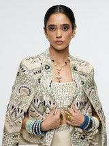 INAYAT EMBELLISHED CAPE JACKET PAIRED WITH METALLIC SCALLOP BUSTIER AND IVORY SLIT SKIRT