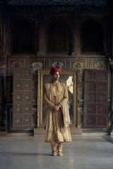 GOLD MATKA SILK ANGRAKHA STYLE SHERWANI WITH CHANDERI BOOTI CHOGA AND CHURIDAR WITH OPTIONAL BELT, STOLE AND WORKED JUTIS