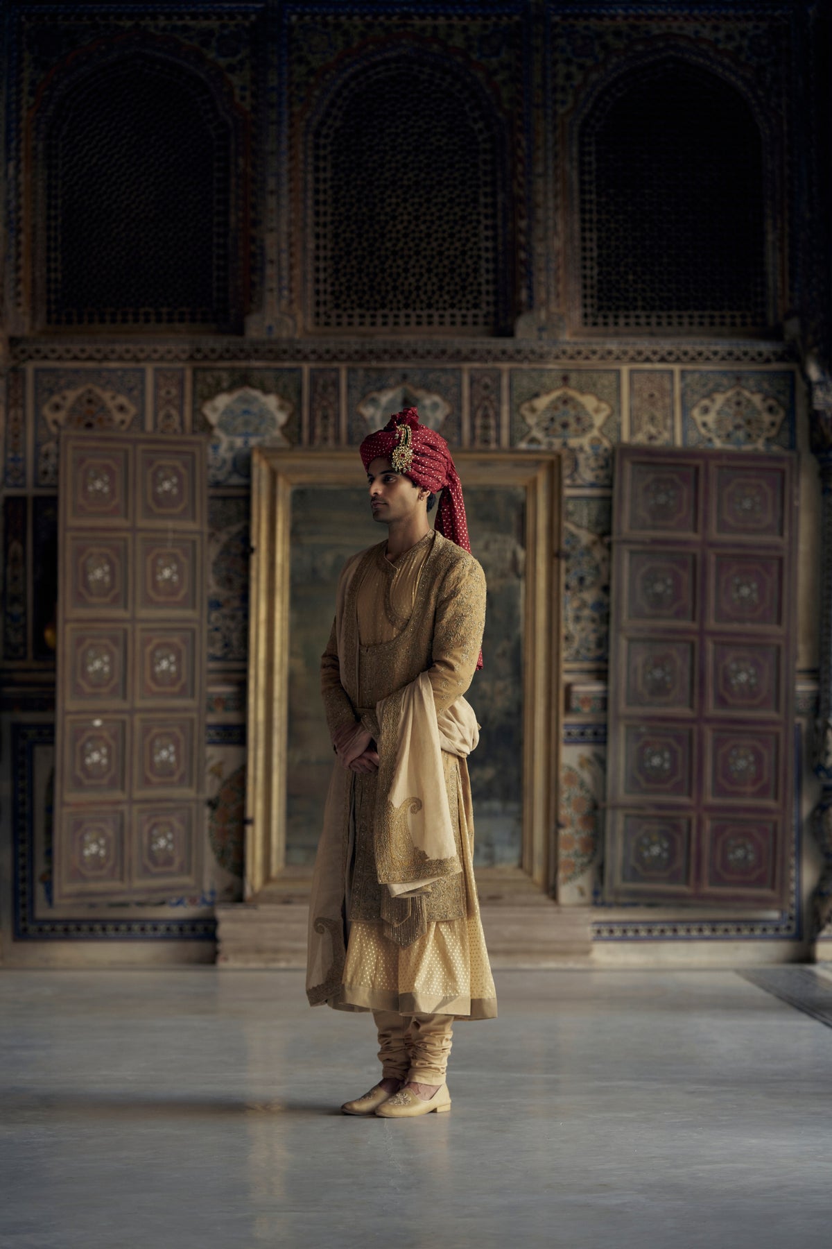 GOLD MATKA SILK ANGRAKHA STYLE SHERWANI WITH CHANDERI BOOTI CHOGA AND CHURIDAR WITH OPTIONAL BELT, STOLE AND WORKED JUTIS