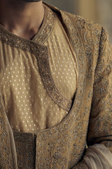 GOLD MATKA SILK ANGRAKHA STYLE SHERWANI WITH CHANDERI BOOTI CHOGA AND CHURIDAR WITH OPTIONAL BELT, STOLE AND WORKED JUTIS