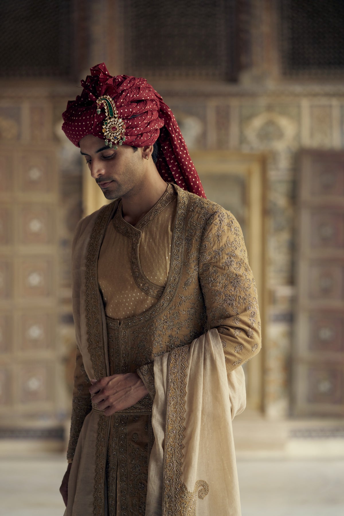 GOLD MATKA SILK ANGRAKHA STYLE SHERWANI WITH CHANDERI BOOTI CHOGA AND CHURIDAR WITH OPTIONAL BELT, STOLE AND WORKED JUTIS
