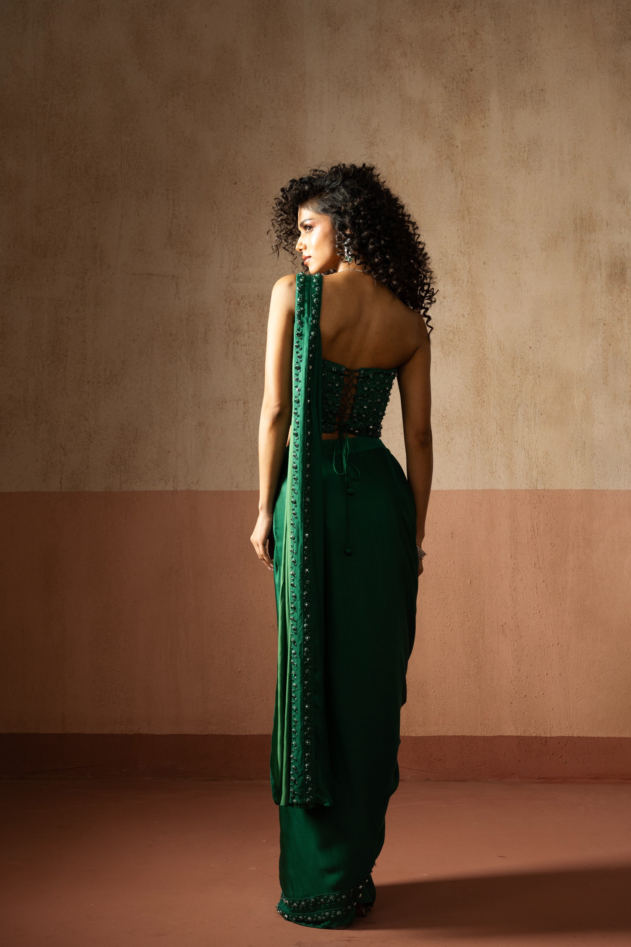 Predraped, emerald green hand embroidered satin saree with corset blouse
