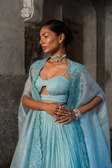 A pwder blue lehenga with maching blouse and cape