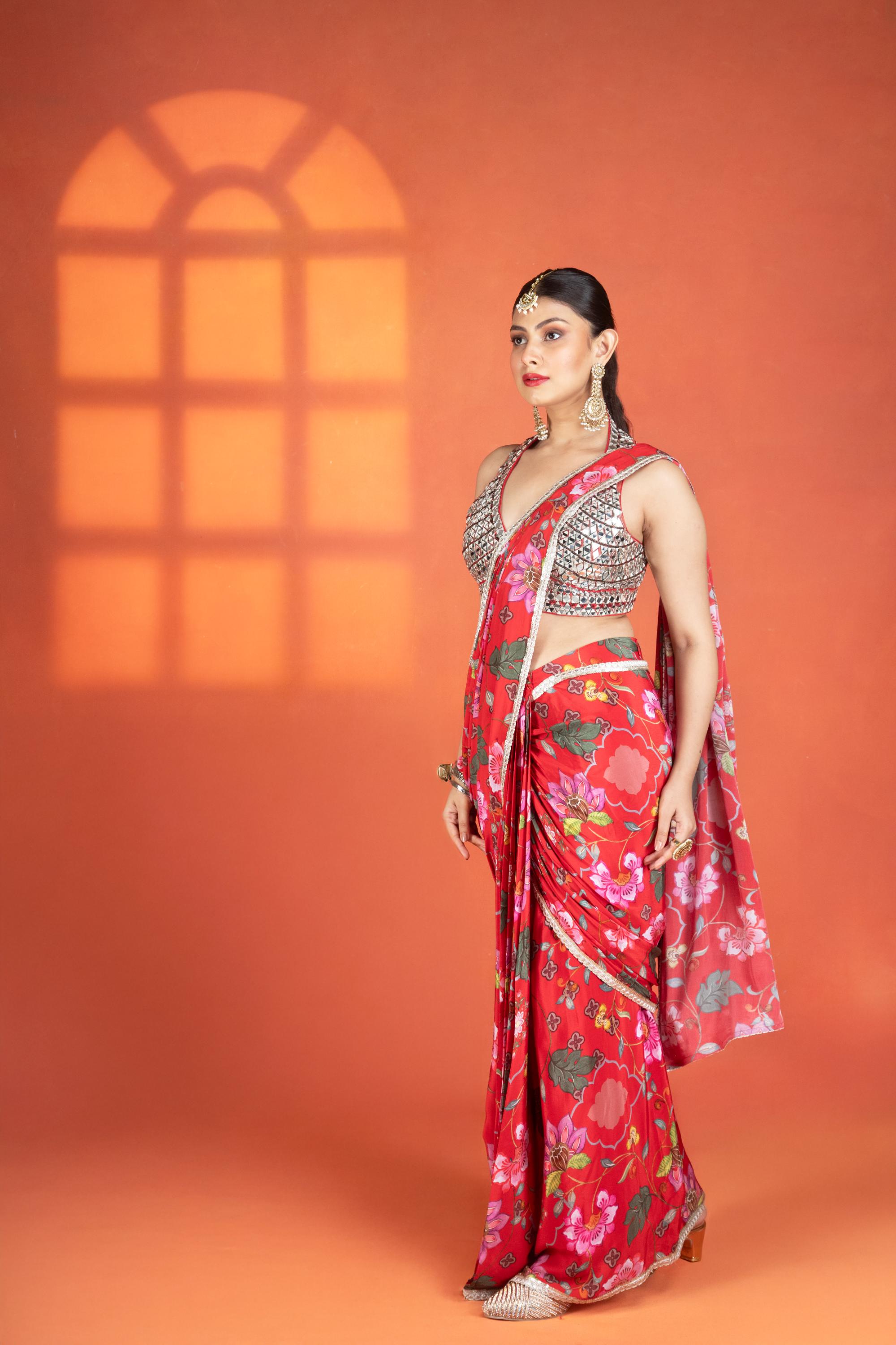 Red floral printed drape saree paired with a heavy mirror-work blouse.