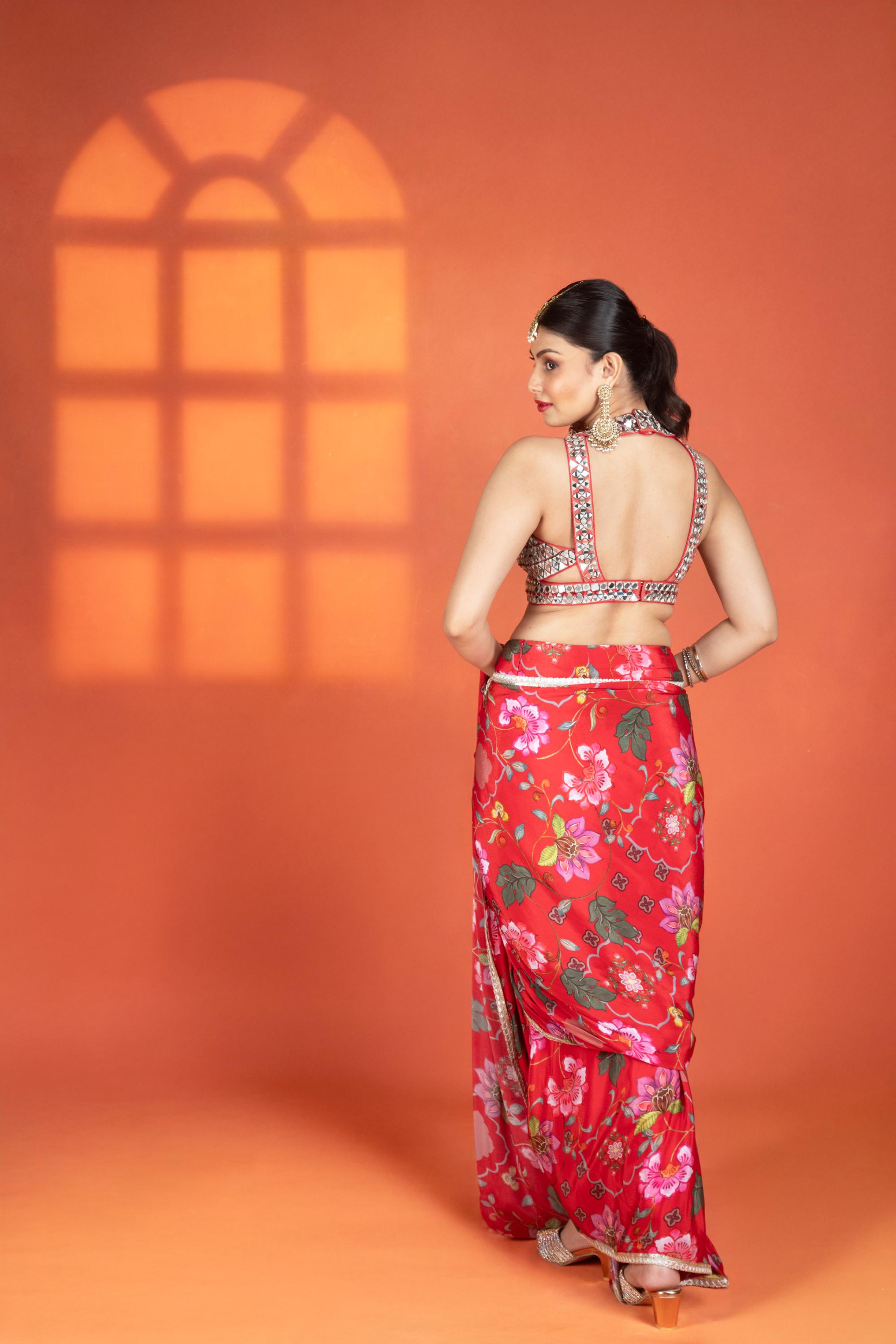 Red floral printed drape saree paired with a heavy mirror-work blouse.