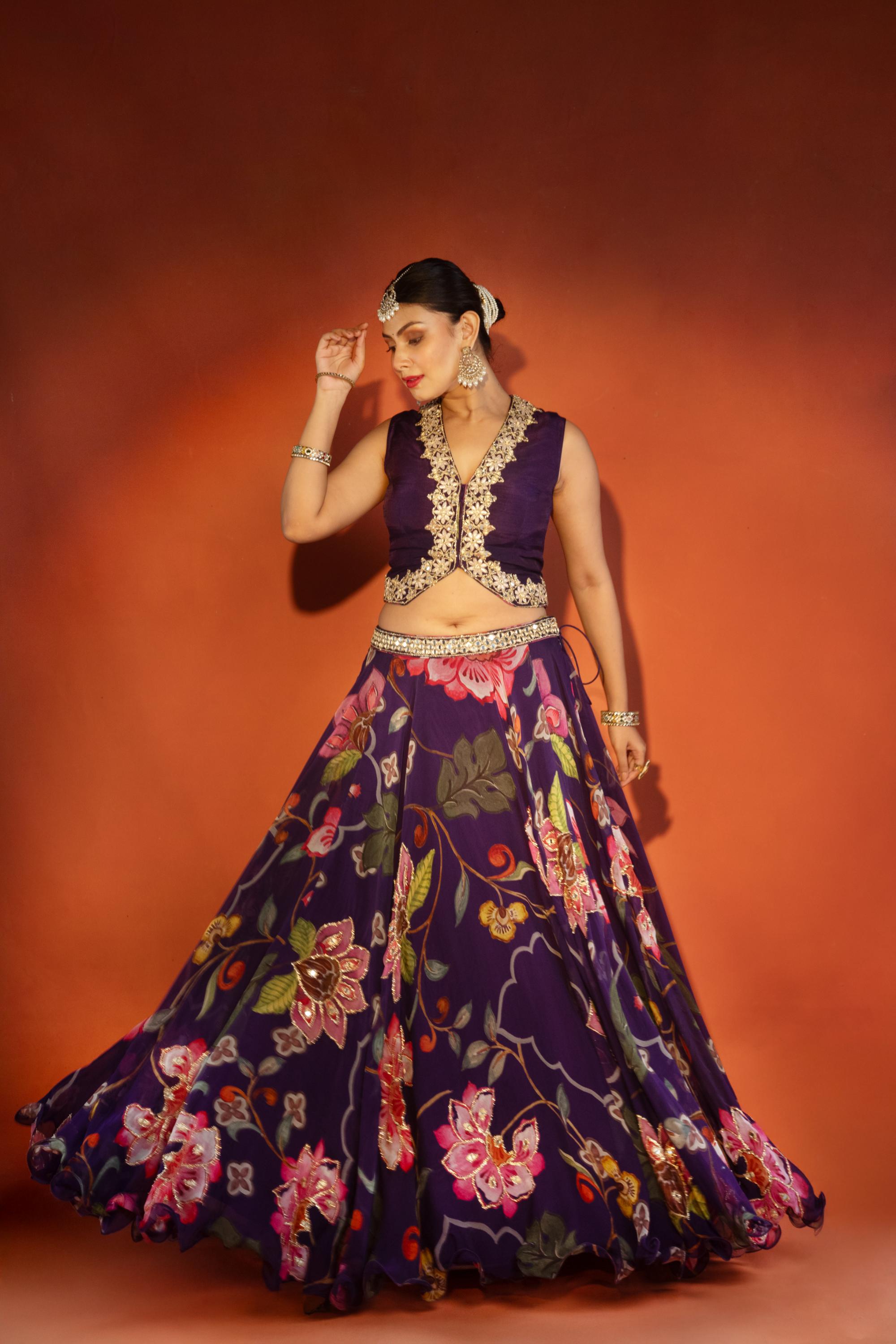 Purple floral lehenga with mirror-work waistcoat and placement dupatta.