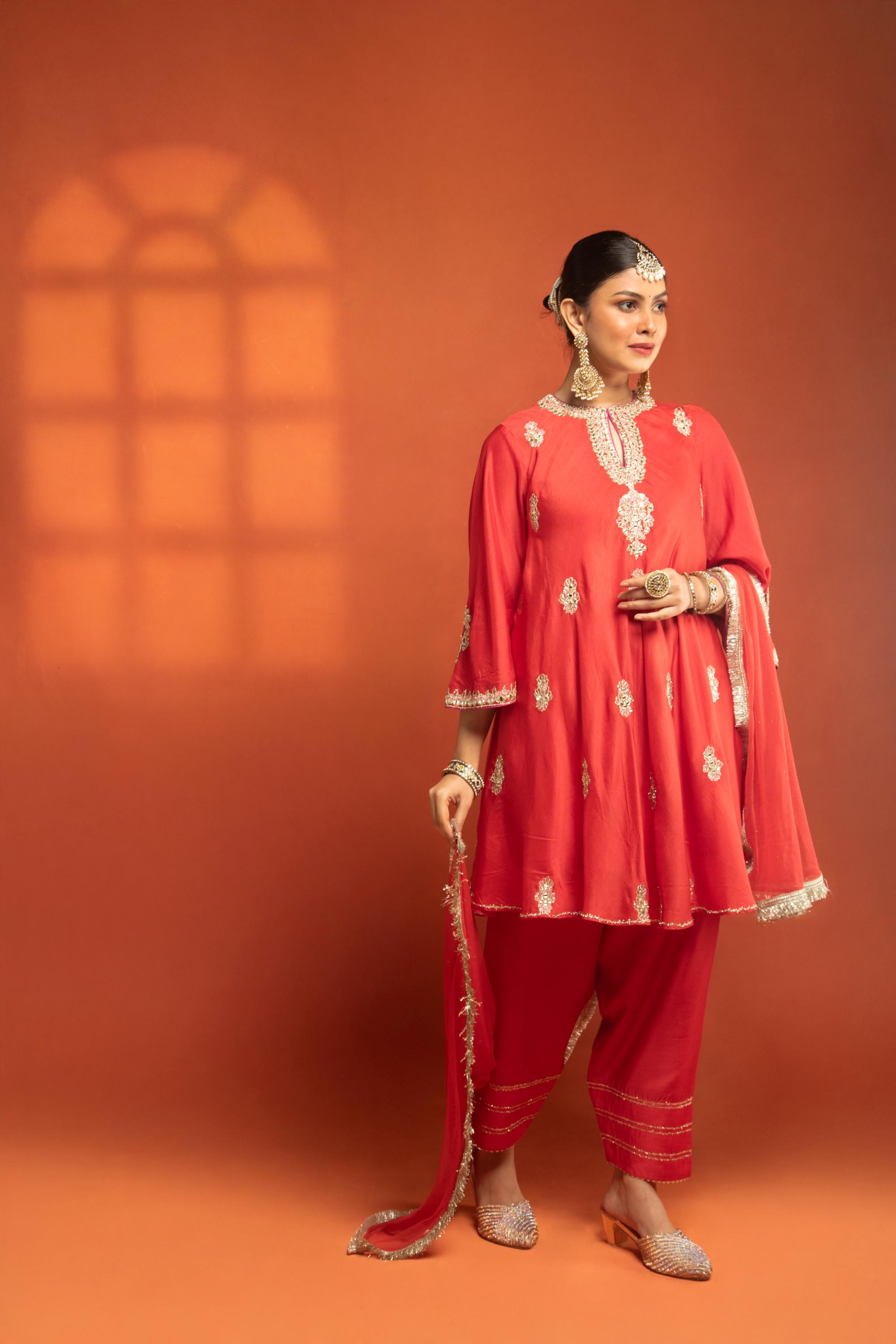 Red Short Semi- Anarkali with a heavily Embroidered Neckline, Paired with Floral Printed Salwar Pants & Dupatta